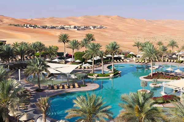 Zonas comunes y piscinas con palmeras hotel Qasar Al Sarab en Abu Dhabi