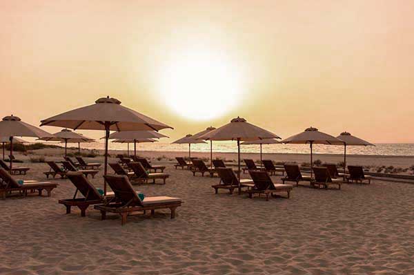 Atardecer sobre la playa sombrillas hotel  St. Regis Saadiyat Island en Abu Dhabi