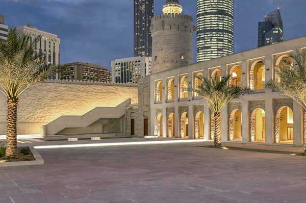 Frente iluminado por la noche del museo museo Qasr Al Hosn en Abu Dhabi