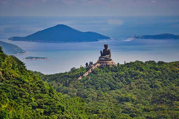 Vista a la isla cercana con vegetación y buda 