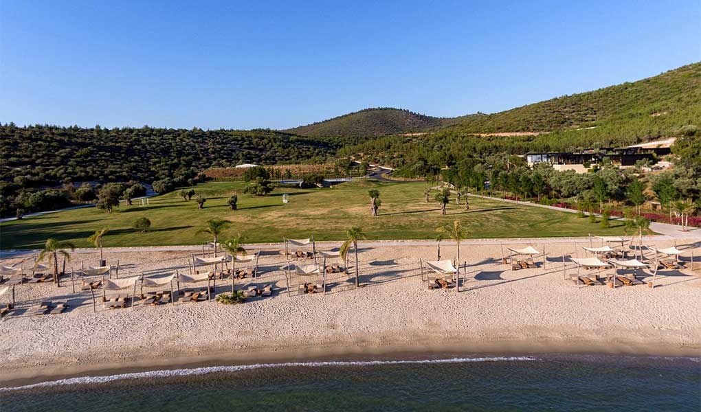 Línea de playa del hotel en Bodrum Turquía con sombrillas blancas 